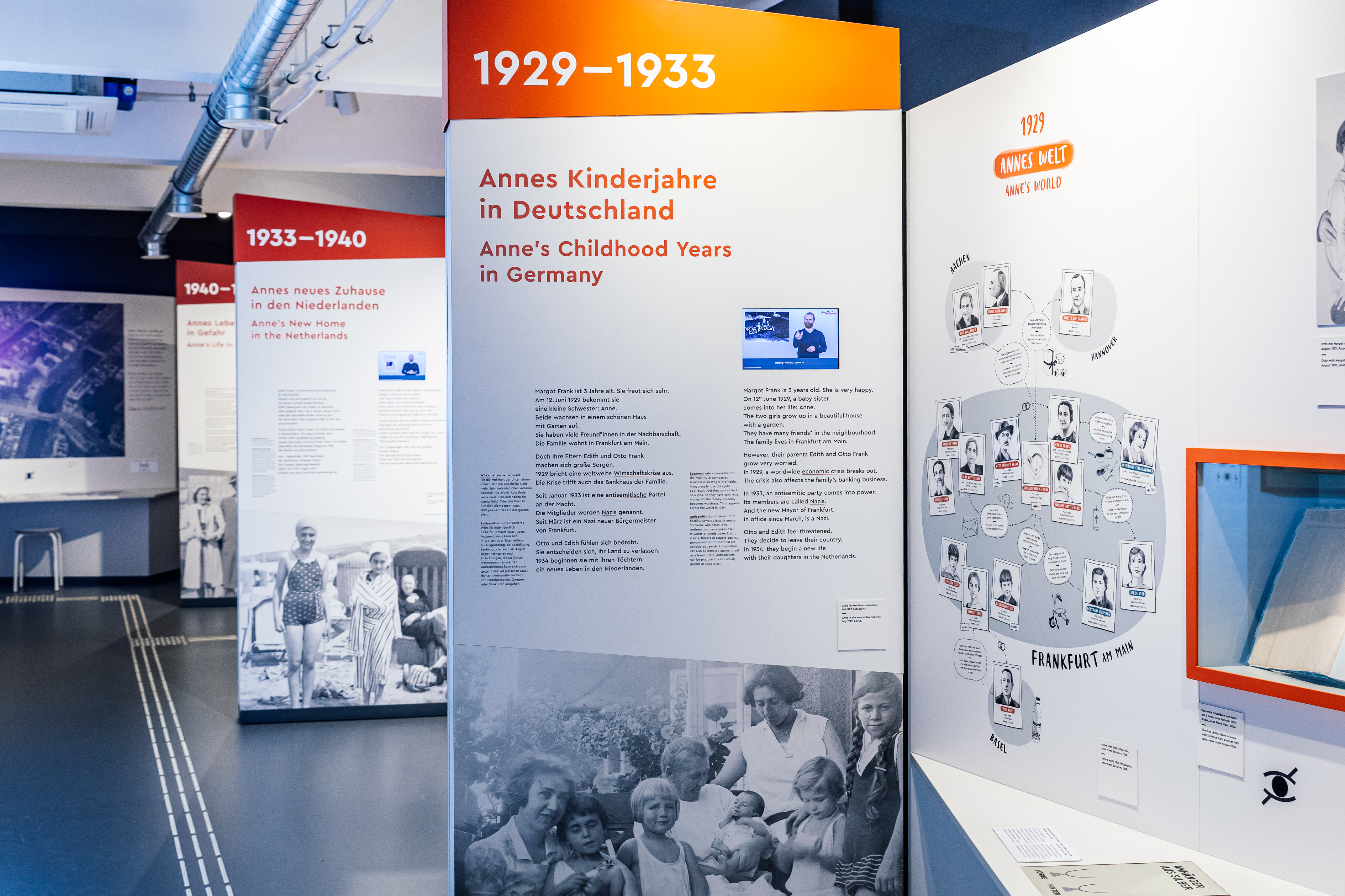 Mehrere Ausstellungswände mit Bild- und Texttafeln sowie Videos in DGS